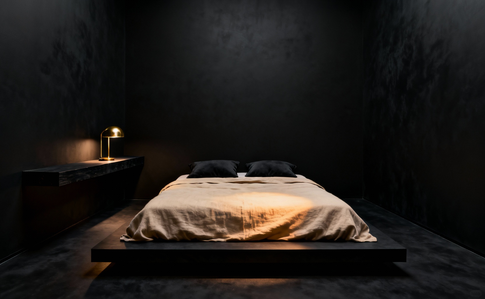 A dramatic and minimalist bedroom painted entirely in ultra-matte obsidian black. The finish absorbs light, creating an 'Infinite Void' effect where the room's corners and boundaries vanish, expanding the perceived space. A low bed with light oatmeal-colored linen provides warm contrast.
