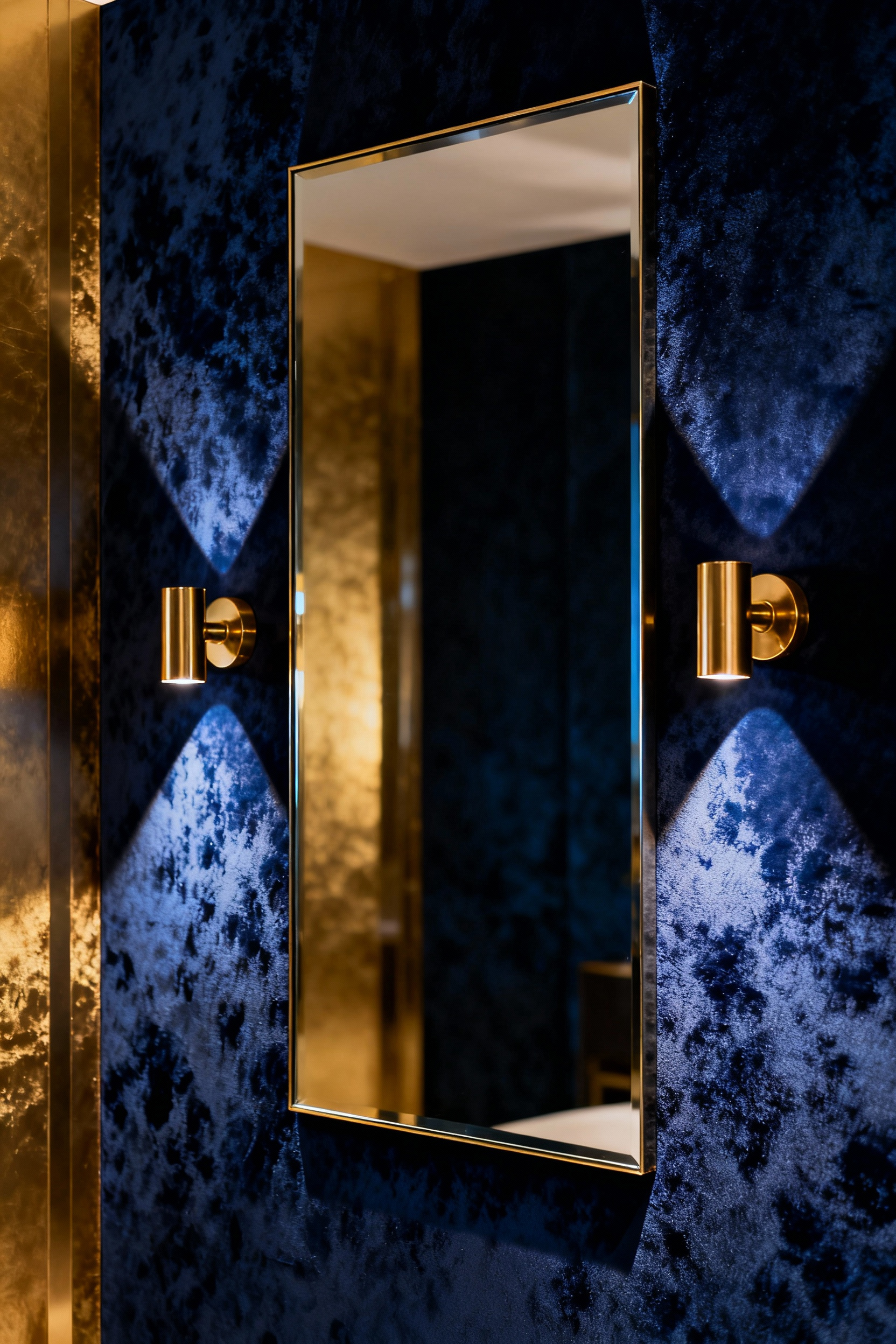 Maximalist bathroom accent wall with luxurious, deeply textured faux-shagreen wallcovering, illuminated by elegant brass sconces emphasizing its haptic depth and rich sensory quality.