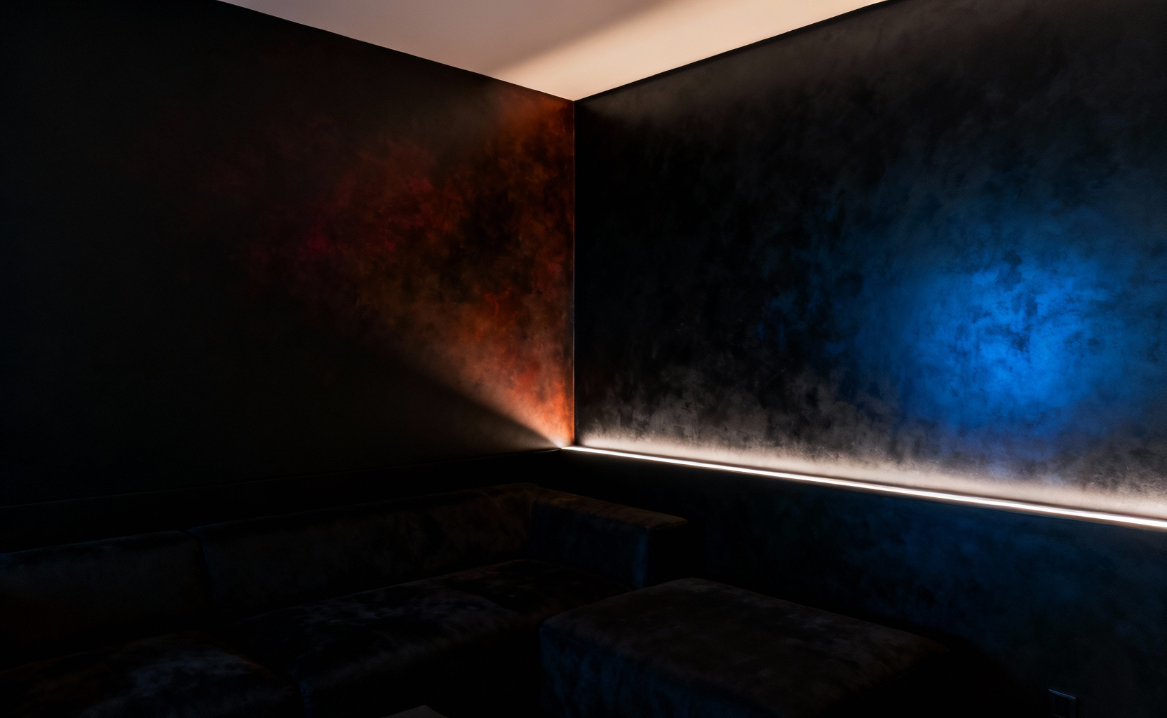 Luxurious living room corner showcasing two distinct black paint undertones (warm brown-black and cool blue-black) under sophisticated lighting, illustrating the impact of pigment nuances in interior design.